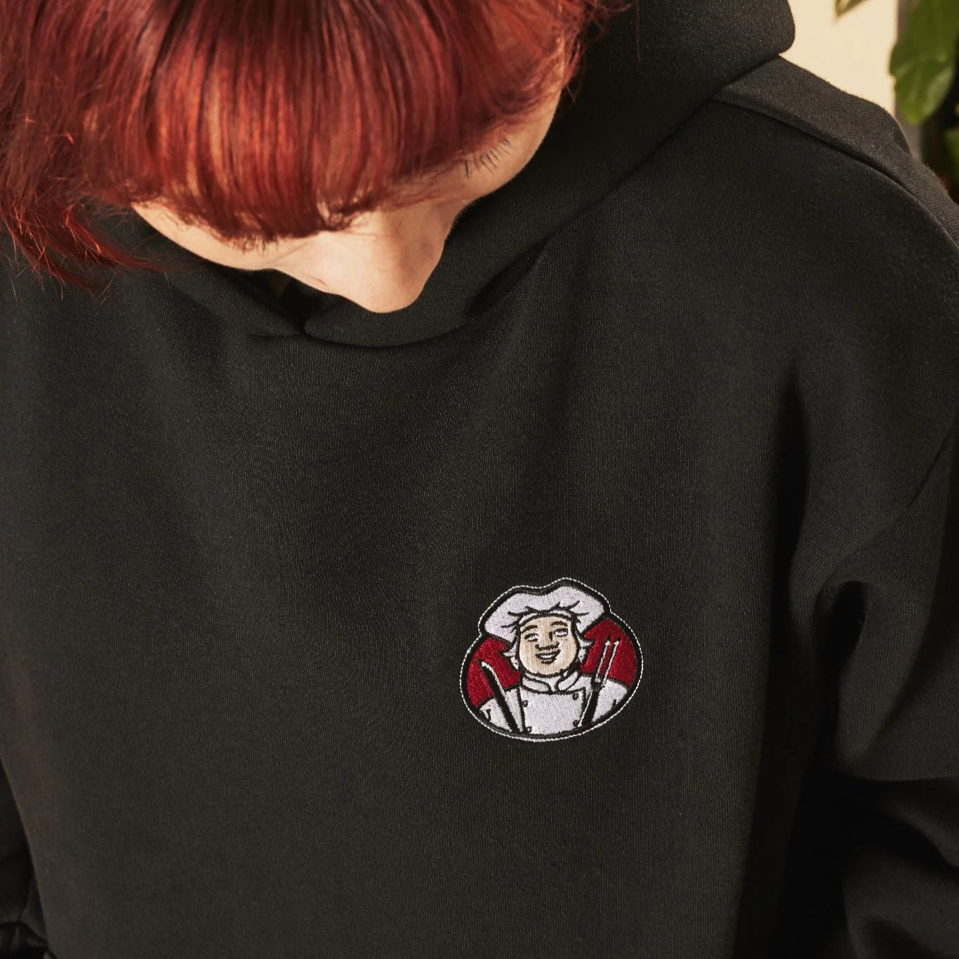 Person wearing a black hoodie with an embroidered Toby Carvery logo on the chest.