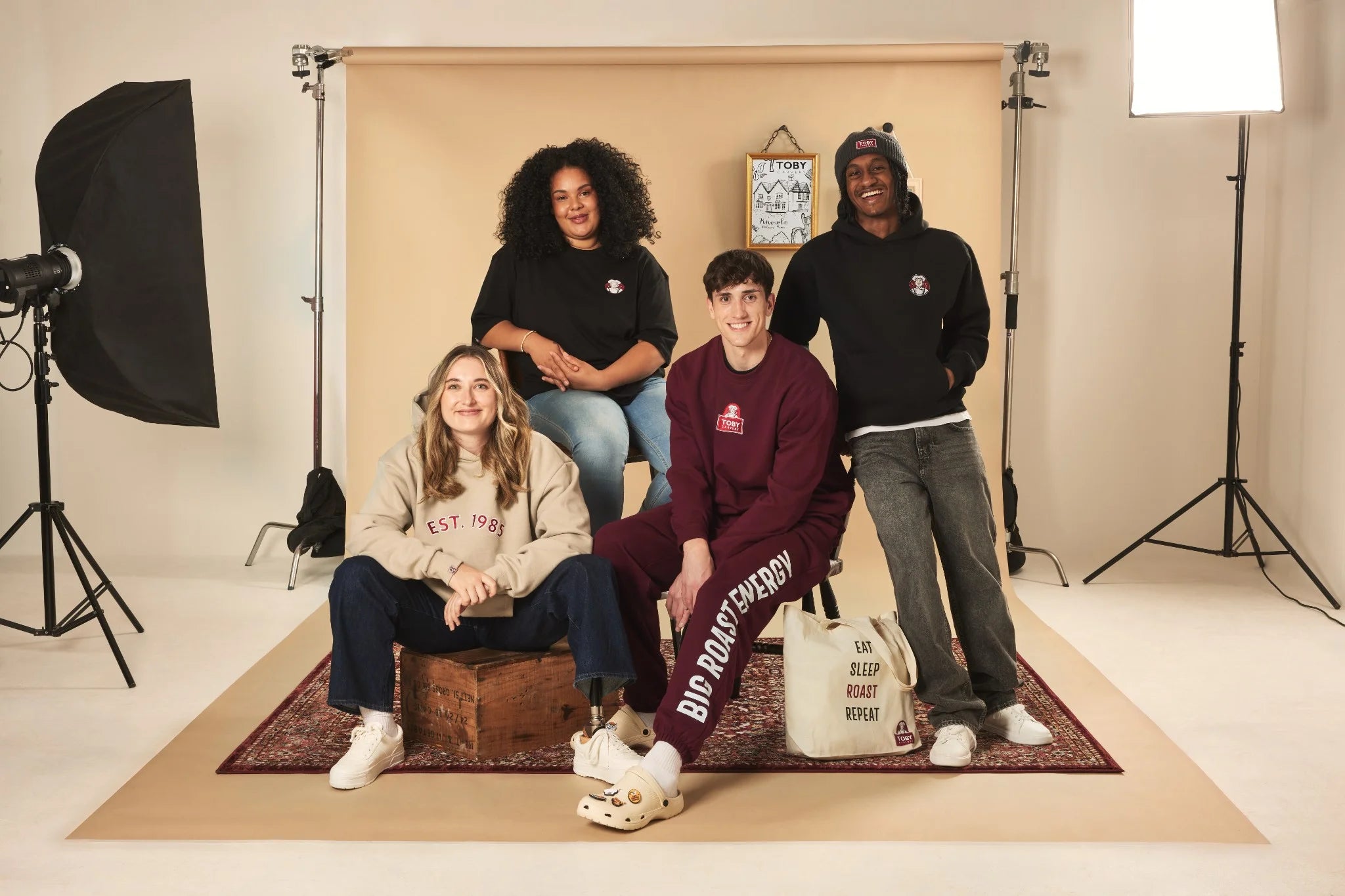 Four people posing in a studio with photography equipment